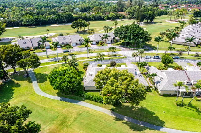 an aerial view of residential houses with outdoor space and trees all around