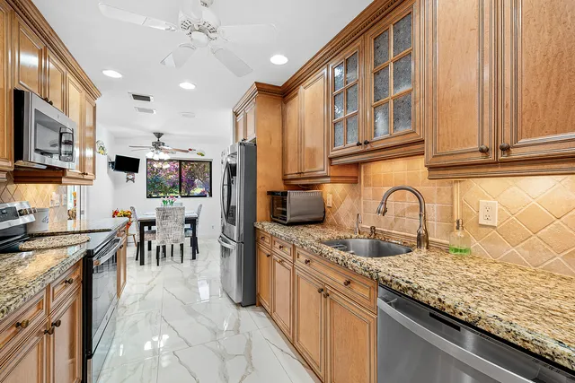 a large kitchen with stainless steel appliances granite countertop a sink and cabinets
