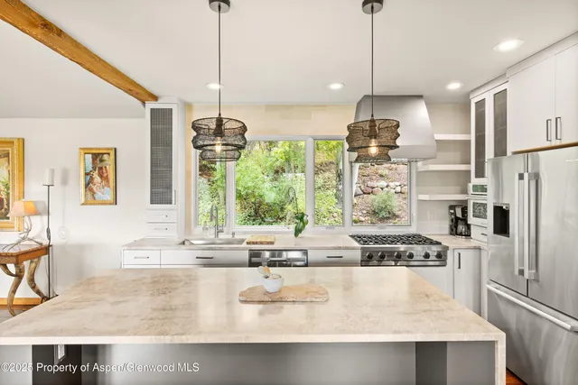 a kitchen with stainless steel appliances granite countertop a sink a stove and a refrigerator