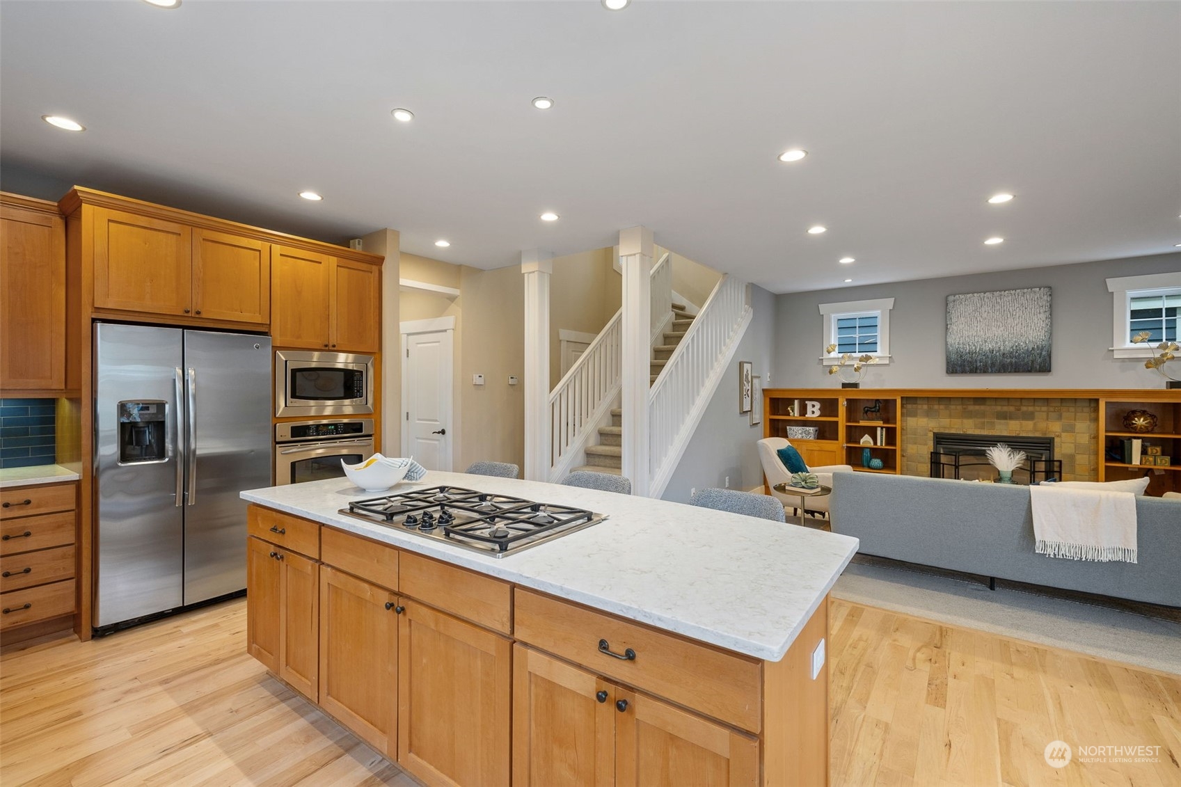 740 North 78th Street Seattle, WA 98103 - Photo 18 of 40 a kitchen with stainless steel appliances kitchen island granite countertop a refrigerator and a stove top oven with white cabinets