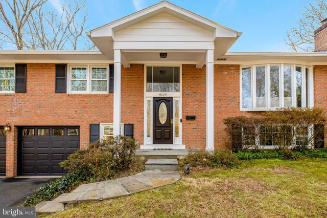 front view of a brick house with a yard