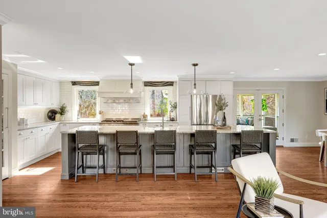 a view of a dining room and livingroom with furniture wooden floor a chandelier