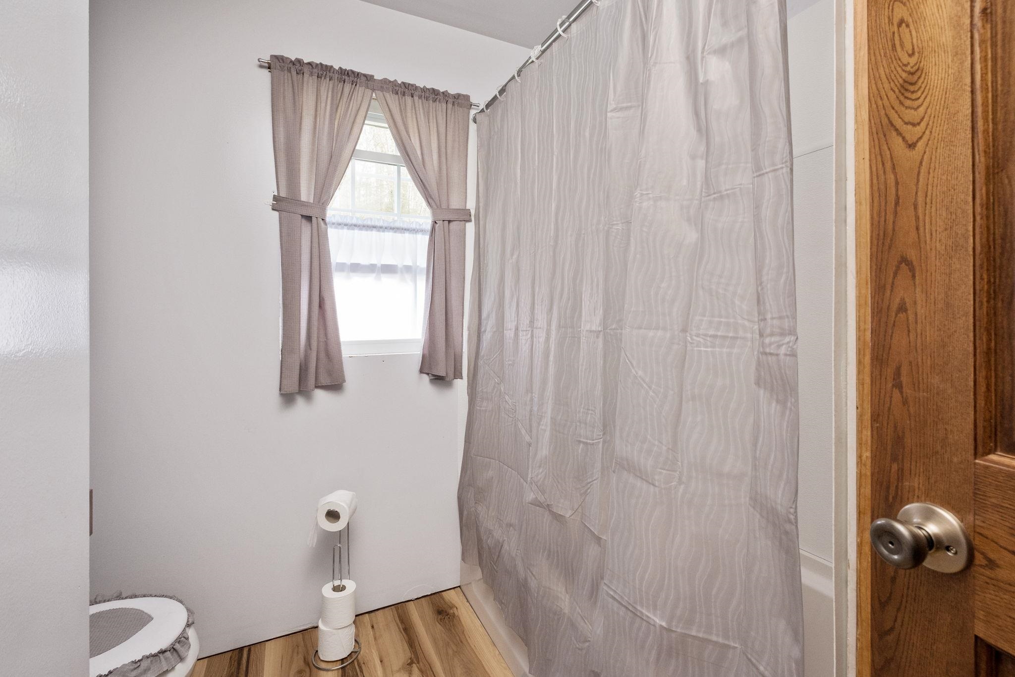 3356 Jackson River Road Monterey, VA 24465 - Photo 22 of 72 a bathroom with a window and a shower curtain