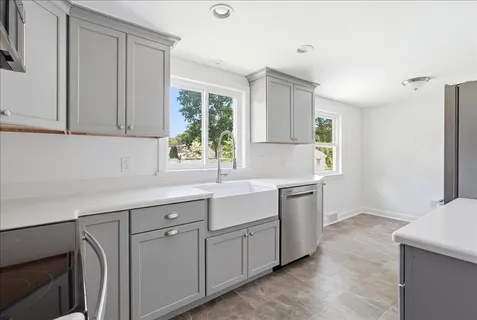a kitchen with white cabinets and window