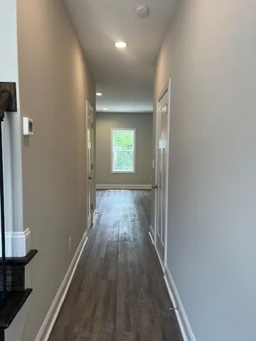 an empty room with wooden floor and a window