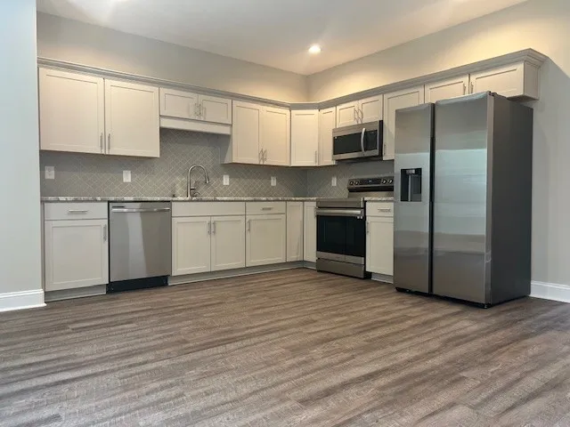 a view of a kitchen with wooden floor and a sink