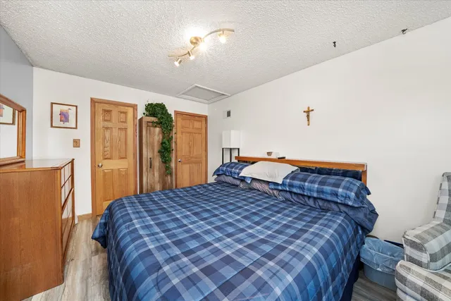 a bedroom with a large bed and a chandelier