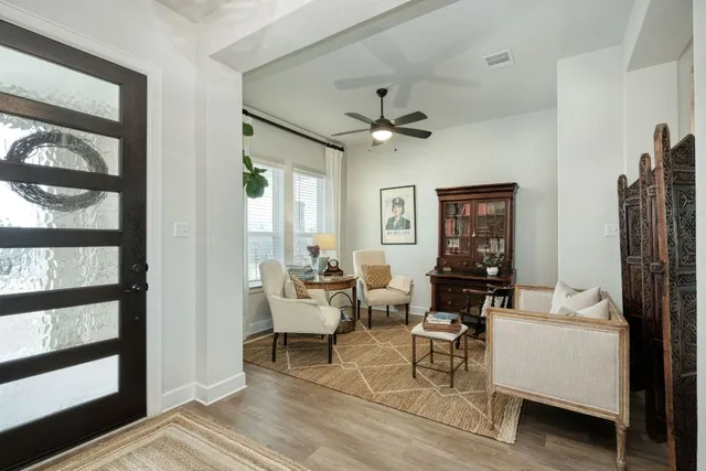 a living room with furniture kitchen view and a chandelier