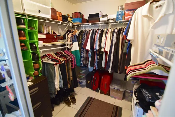 a view of walk in closet with clothes and shoes