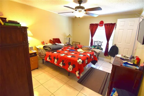 a bedroom with a bed and dresser with wooden floor