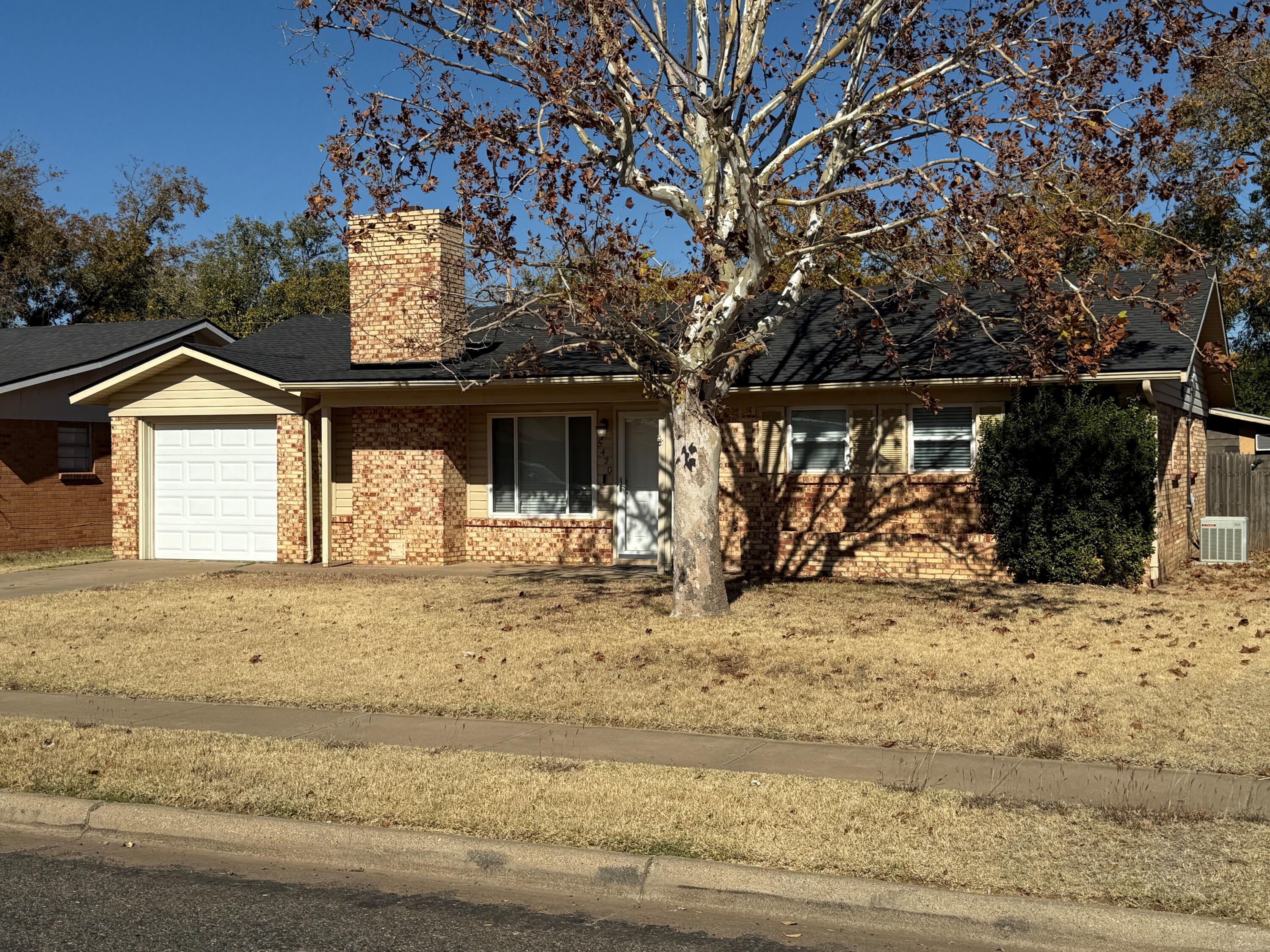 a front view of a house with a yard covered with snow