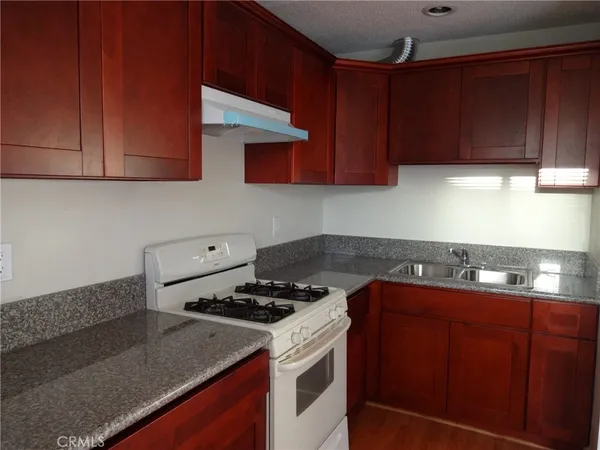 a kitchen with sink cabinets and stove top oven