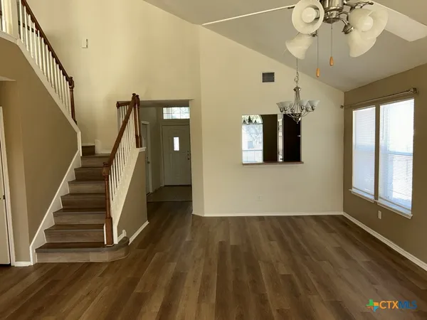 a view of a hallway with wooden floor and staircase