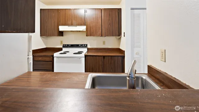 a kitchen with a stove and a refrigerator with wooden floor