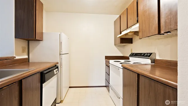 a kitchen with stainless steel appliances granite countertop a refrigerator and a stove