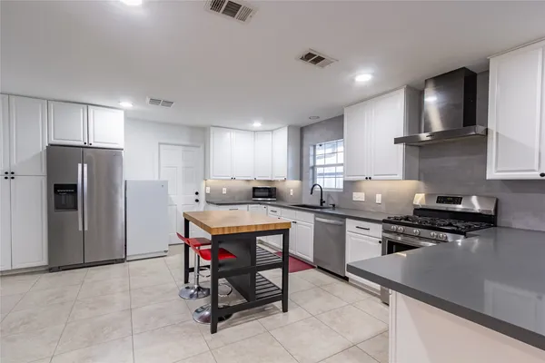 a kitchen with a stove a sink and a refrigerator