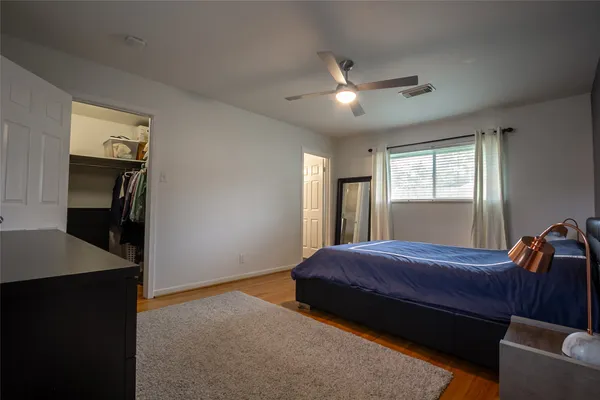 a bedroom with a bed and a ceiling fan