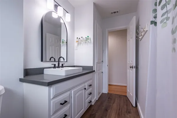 a spacious bathroom with a toilet sink and mirror