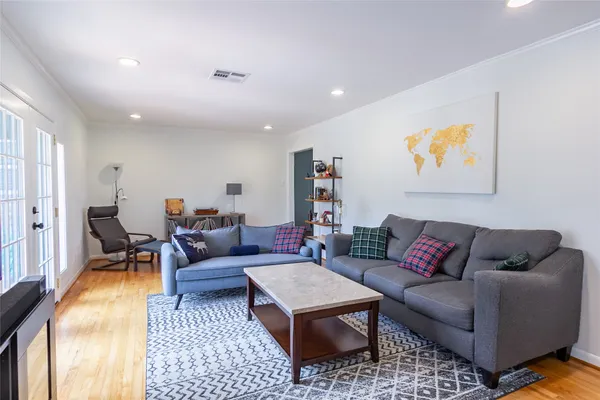 a kitchen with a table a refrigerator a stove a dining table and chairs with wooden floor