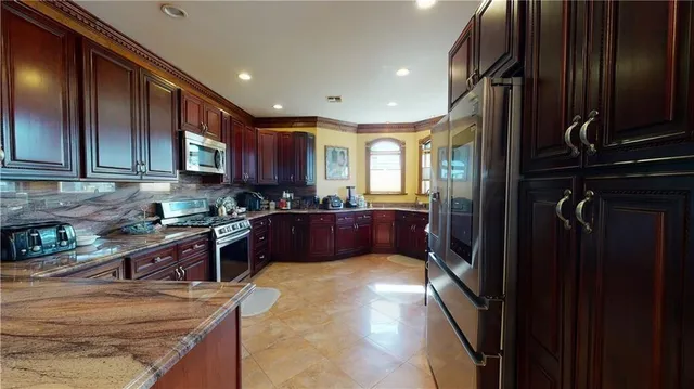 a kitchen with stainless steel appliances granite countertop wooden cabinets and a stove top oven