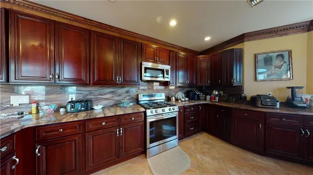 a kitchen with stainless steel appliances granite countertop wooden cabinets a stove top oven a sink and dishwasher