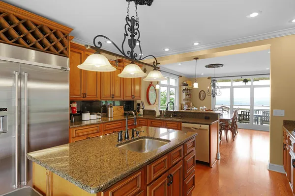 a kitchen with granite countertop a sink a counter top space and stainless steel appliances
