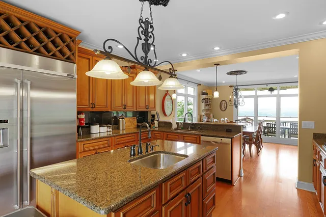 a kitchen with granite countertop a sink a counter top space and stainless steel appliances