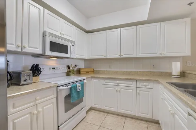 a kitchen with white cabinets and white appliances
