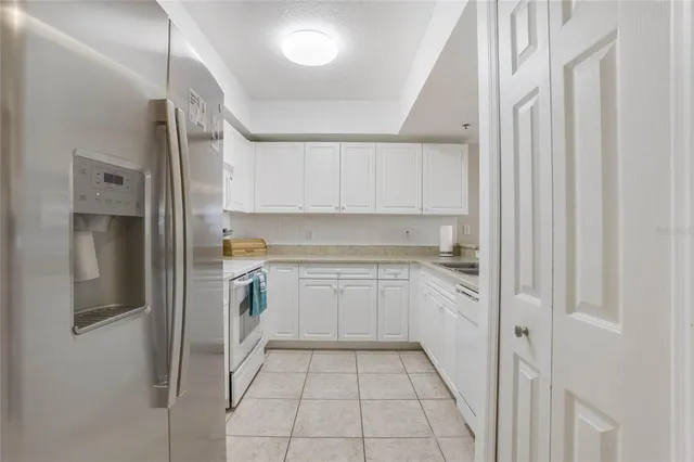 a kitchen with white cabinets and a refrigerator