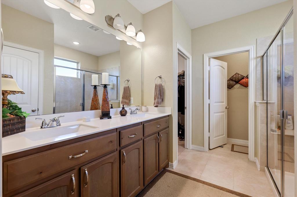 2375 County Road 4010 Decatur, TX 76234 - Photo 15 of 34 Full bathroom featuring double vanity, light tile patterned flooring, a shower stall, and a walk in closet