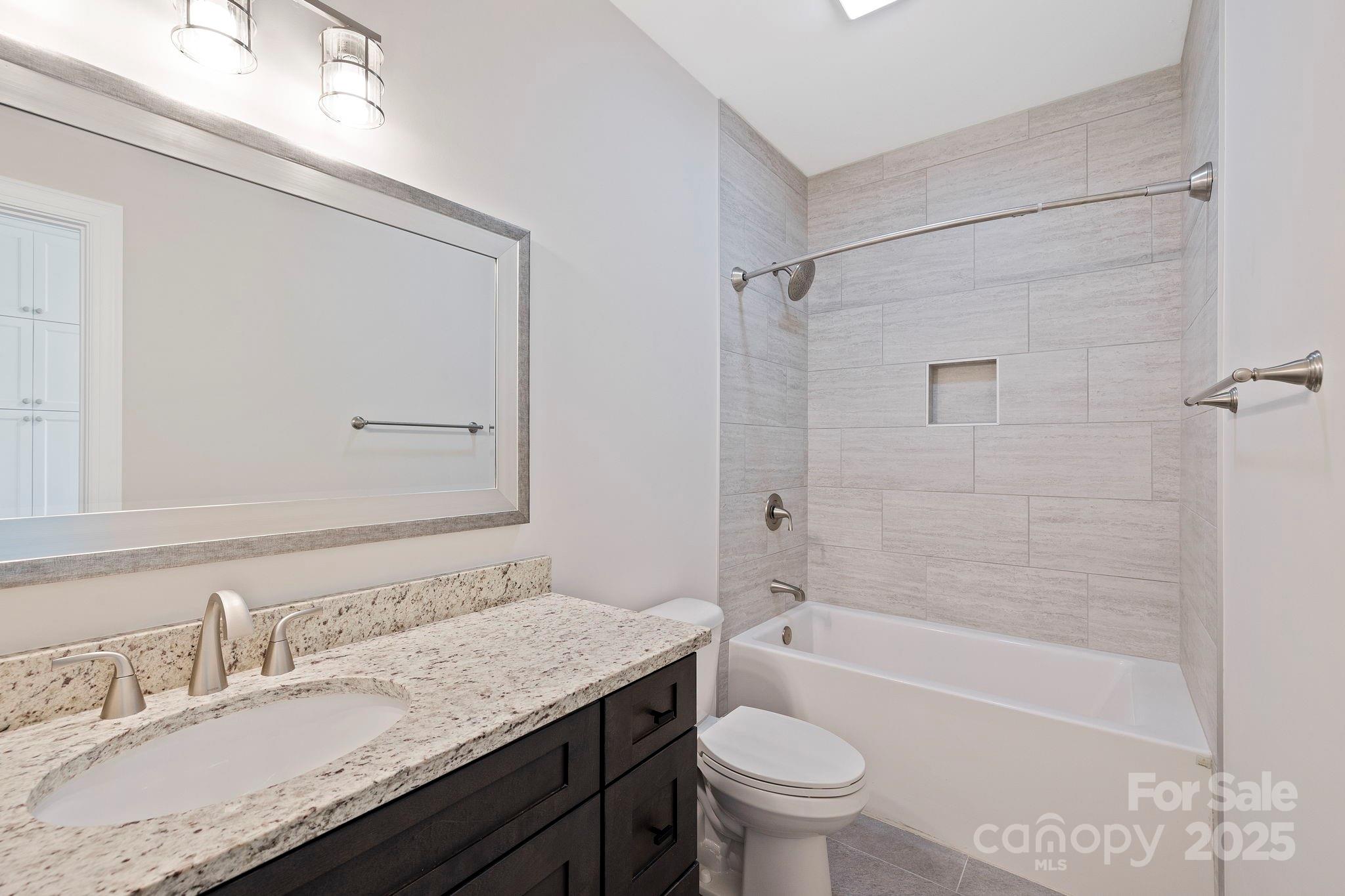 73 Wisdom Cove Road Flat Rock, NC 28731 - Photo 21 of 41 a bathroom with a granite countertop sink a toilet and bathtub