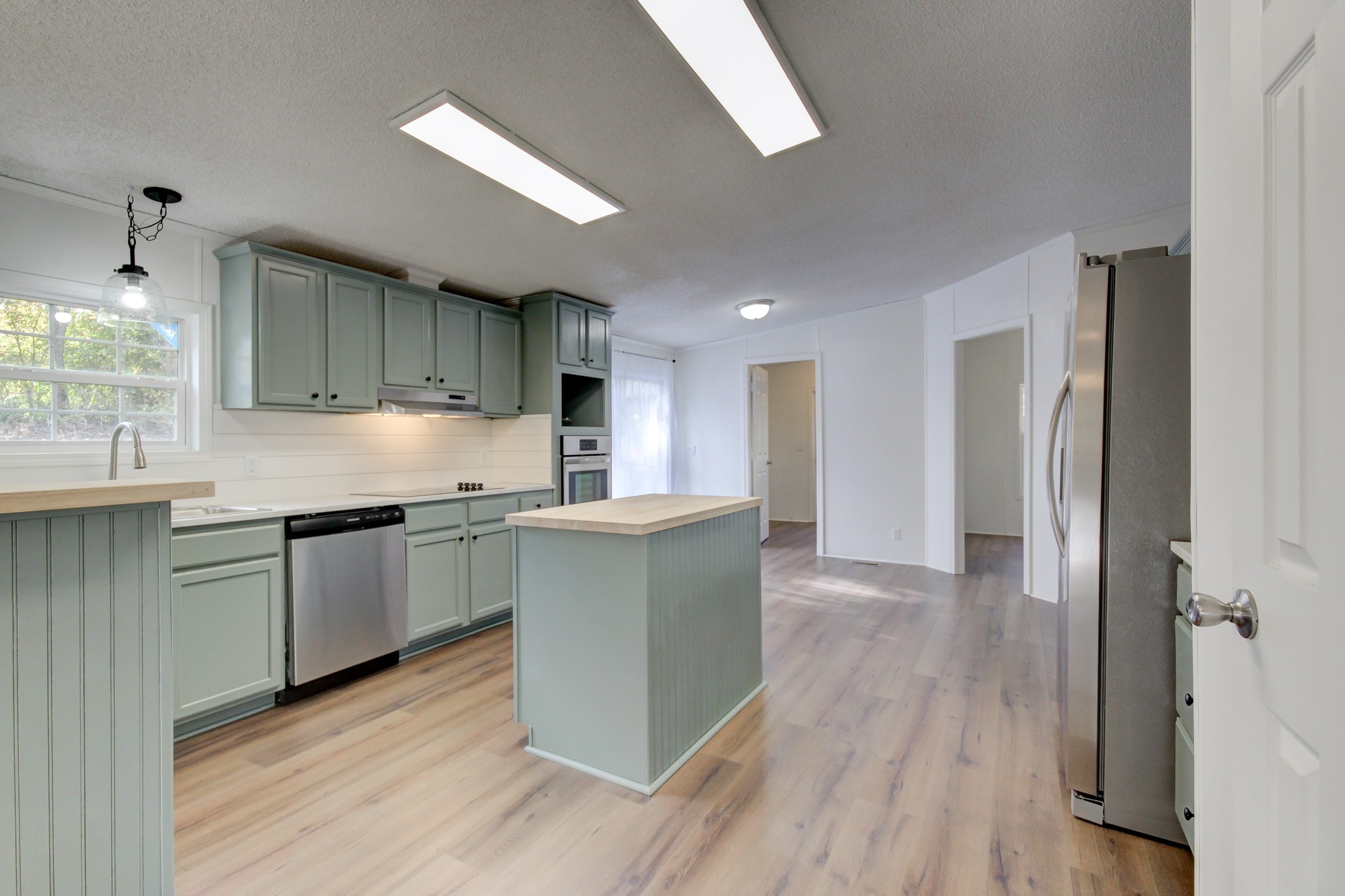 145 Trotter Road Cunningham, TN 37052 - Photo 4 of 48 a kitchen with stainless steel appliances granite countertop a refrigerator a sink dishwasher a stove and white countertops with wooden floor