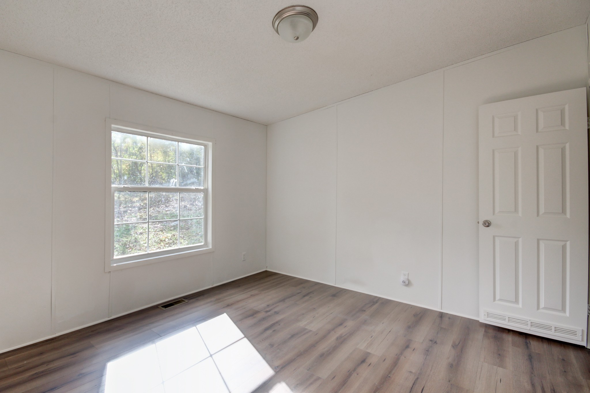 145 Trotter Road Cunningham, TN 37052 - Photo 40 of 48 an empty room with wooden floor and windows