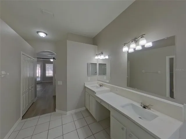 a spacious bathroom with a double vanity sink a mirror and a shower