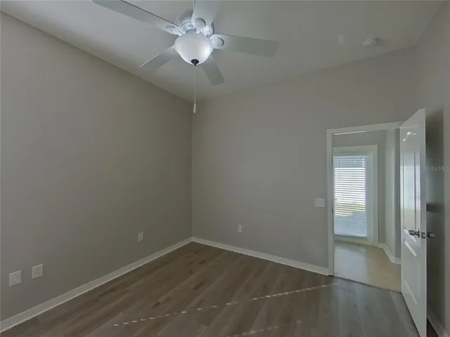 an empty room with a window and a fan