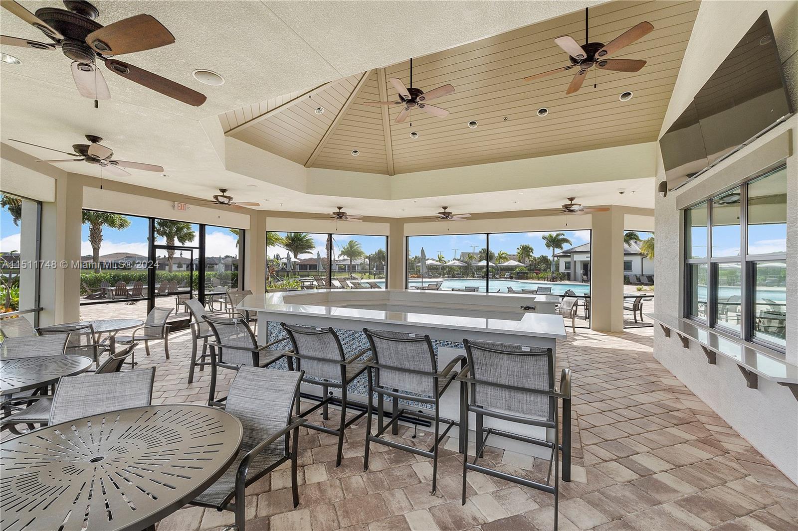 8339 Cadre Noir Road Lake Worth, FL 33467 - Photo 16 of 44 a room with lots of wooden furniture and large windows