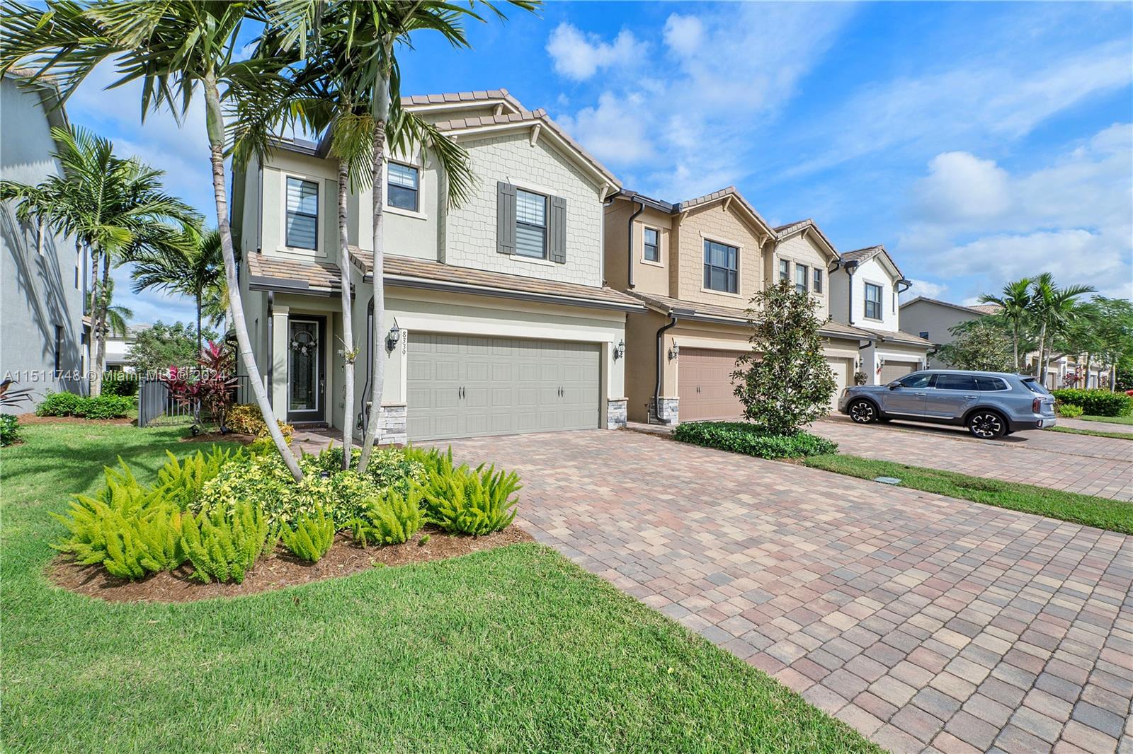 8339 Cadre Noir Road Lake Worth, FL 33467 - Photo 24 of 44 a front view of a house with a garden and trees