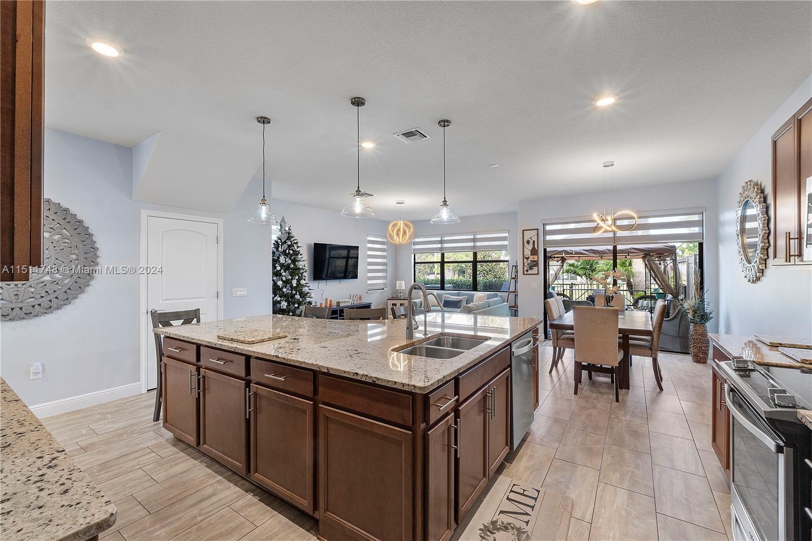 8339 Cadre Noir Road Lake Worth, FL 33467 - Photo 36 of 44 a kitchen with kitchen island a large counter top space a sink stainless steel appliances and windows