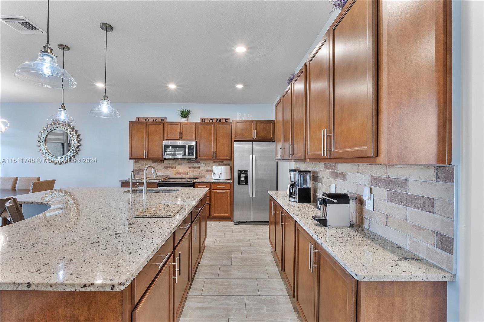 8339 Cadre Noir Road Lake Worth, FL 33467 - Photo 40 of 44 a large kitchen with stainless steel appliances granite countertop plenty wooden cabinets