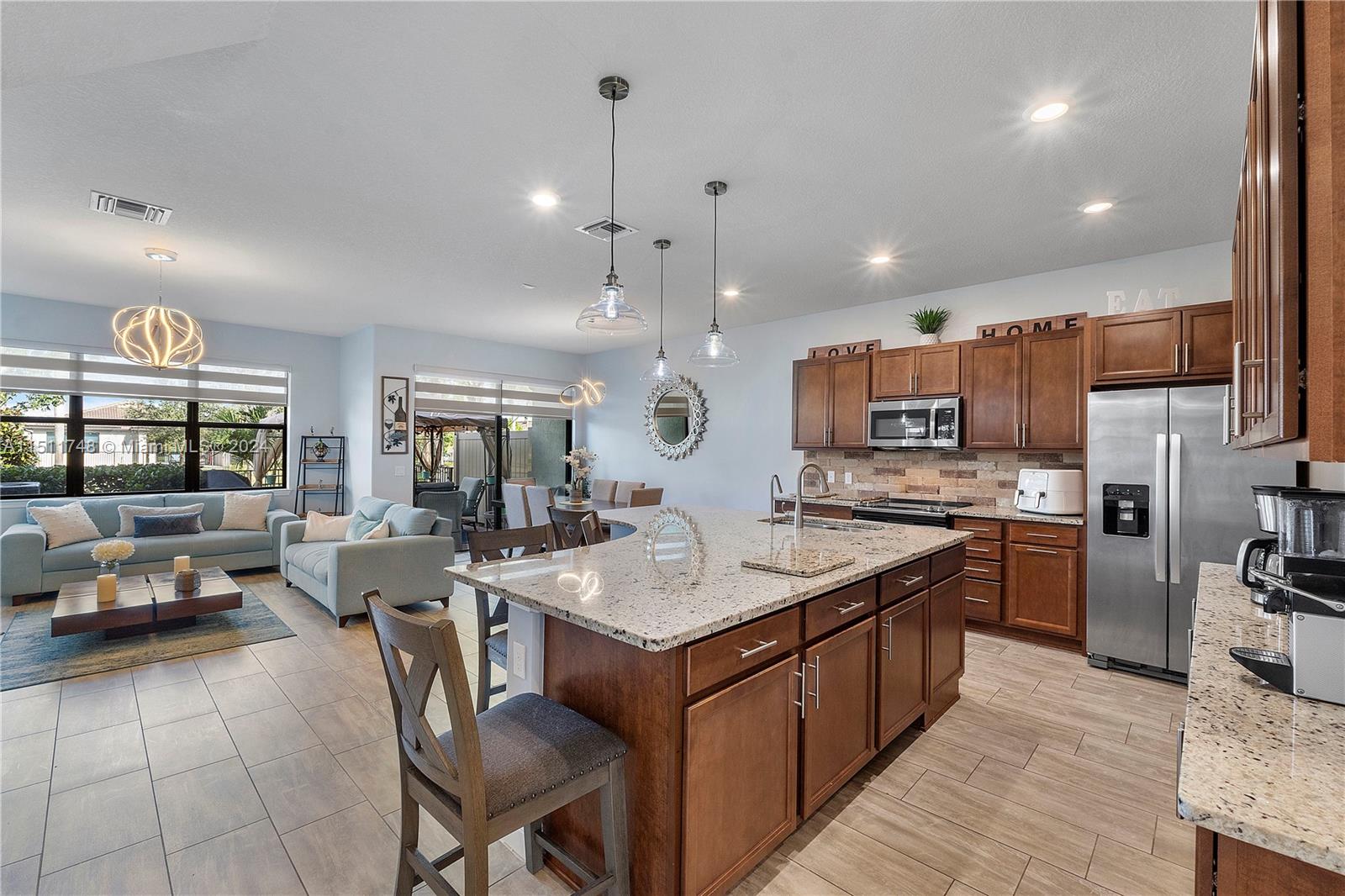 8339 Cadre Noir Road Lake Worth, FL 33467 - Photo 41 of 44 a open kitchen with stainless steel appliances granite countertop a stove and a refrigerator