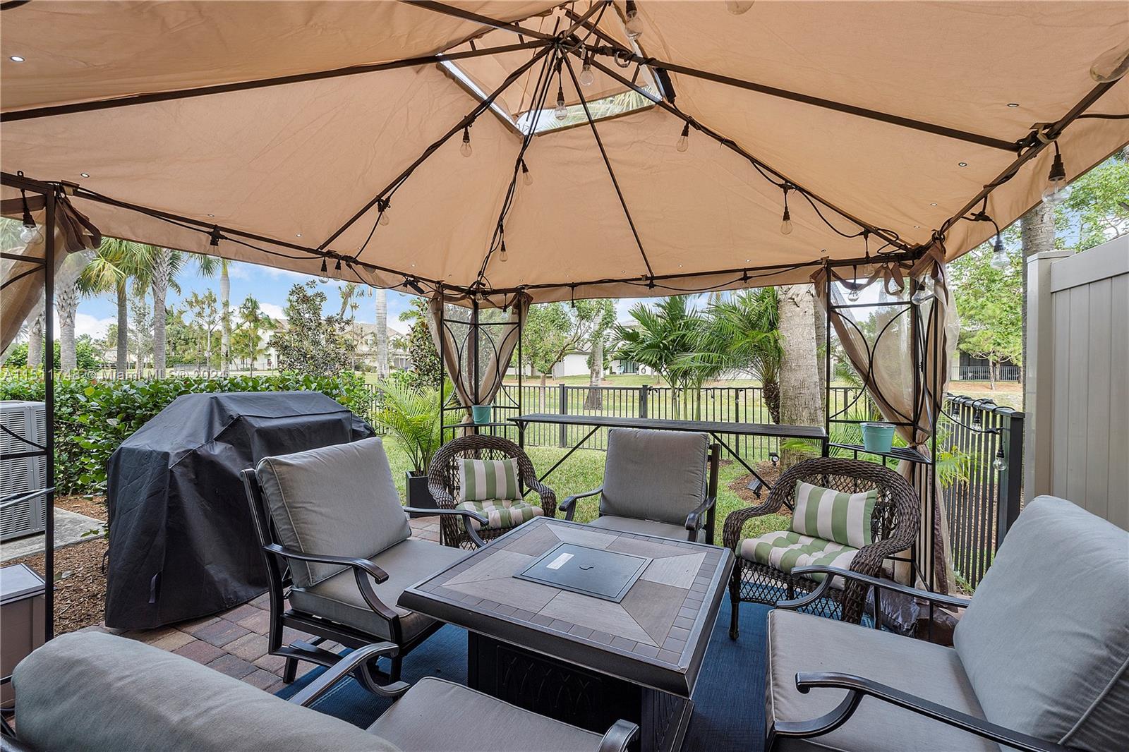 8339 Cadre Noir Road Lake Worth, FL 33467 - Photo 7 of 44 a view of a patio with couches chairs under an umbrella