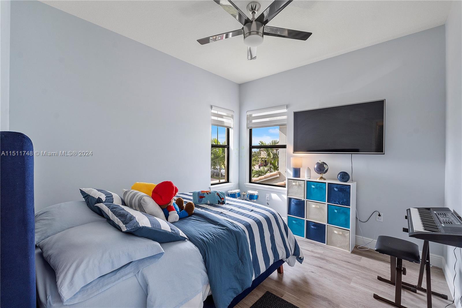 8339 Cadre Noir Road Lake Worth, FL 33467 - Photo 8 of 44 a bedroom with a bed and a flat screen tv