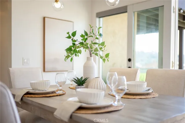 a large white kitchen with a stove a refrigerator a sink dishwasher with a dining table and chairs