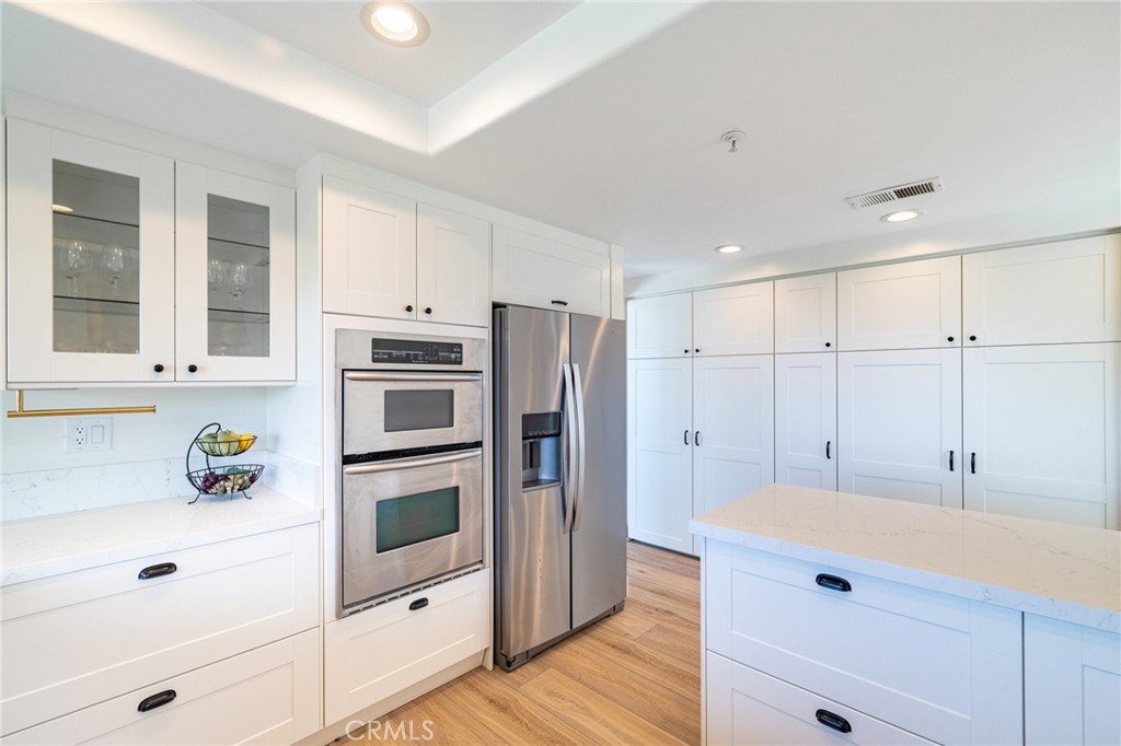 27 Burriana San Clemente, CA 92672 - Photo 23 of 66 a kitchen with a refrigerator and white cabinets