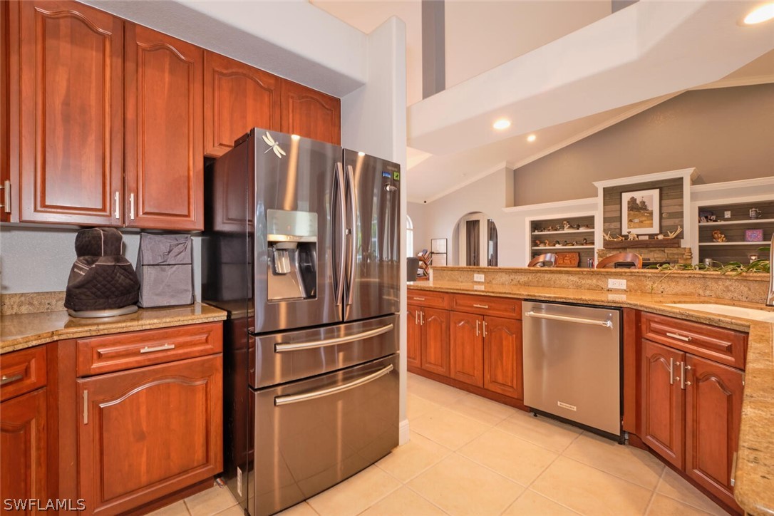 2050 Balsey Road Alva, FL 33920 - Photo 13 of 35 a kitchen with stainless steel appliances granite countertop a refrigerator and wooden cabinets