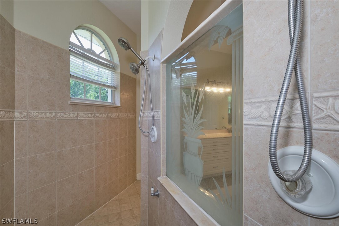 2050 Balsey Road Alva, FL 33920 - Photo 17 of 35 a bathroom with a glass shower door and a mirror