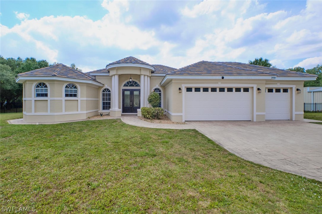 2050 Balsey Road Alva, FL 33920 - Photo 3 of 35 a front view of a house with garden