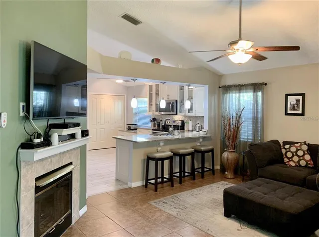a living room with stainless steel appliances kitchen island granite countertop furniture and a flat screen tv