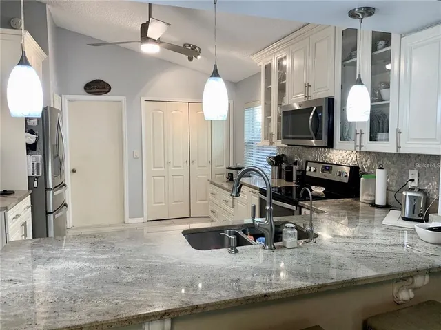 a kitchen with sink stove and refrigerator