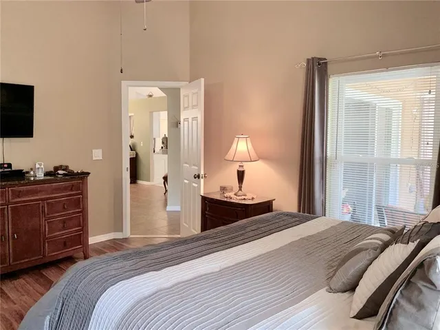 a bedroom with a bed and a flat tv screen on dresser